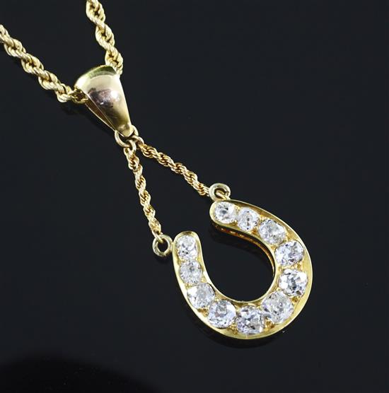 A yellow metal diamond-set horseshoe pendant on 9ct gold chain, pendant 21mm.